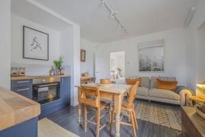 a kitchen and living room with a table and a couch at New The Barley Rustic luxury in Cirencester