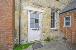 an old brick house with a white door and windows at New The Barley Rustic luxury in Cirencester