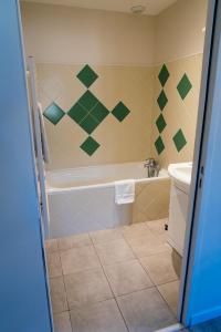 a bathroom with a tub and a sink at Hôtel Bistrot Les Tanins in Saint-Antoine