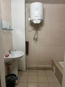 a bathroom with a sink and a water tank at Оазис in Lutsk