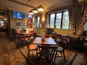 a restaurant with tables and chairs and windows at Pendle Inn in Barrowford
