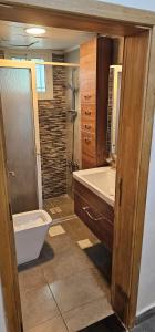 a bathroom with a shower and a toilet and a sink at Square Resident in Monrovia +14 photos