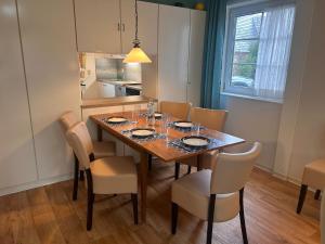 a dining room with a wooden table and chairs at Küstenhuus in Utersum
