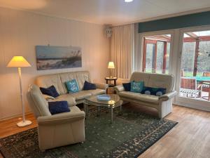 a living room with a couch and chairs and a table at Küstenhuus in Utersum