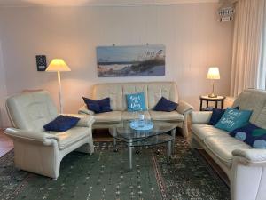 a living room with two couches and a coffee table at Küstenhuus in Utersum +12 photos