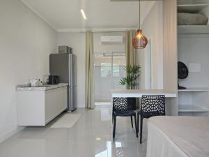 a kitchen with a refrigerator and a table and chairs at Studio 02# Aconchego e tranquilidade em Floripa Muito Top e tranquilo in Florianópolis