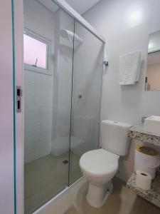 a bathroom with a toilet and a glass shower at Studio 02# Aconchego e tranquilidade em Floripa Muito Top e tranquilo in Florianópolis +20 photos