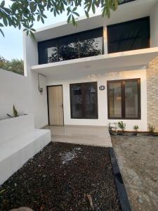 a large white house with a driveway at Adah 786 Villa Syariah in Krian