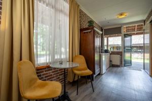 a room with a table and chairs and a kitchen at Buitengoed de Panoven in Zevenaar