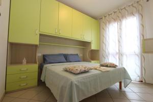 a bedroom with a bed with yellow cabinets at Residence Sole&Mare in Rosapineta