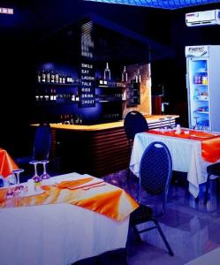 ein Restaurant mit zwei Tischen und Stühlen und einer Bar in der Unterkunft Premium HOTEL in Douala
