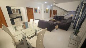 a living room with a glass table and chairs at Four Squares by WIH in Karachi