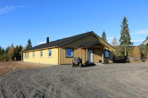 a yellow building with a car parked in front of it at General House in Namsskogan