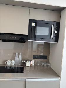 a microwave above a kitchen counter with vases at Yamunaviewnest in Noida +4 photos
