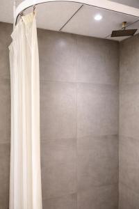 a shower with a white shower curtain in a bathroom at Yamunaviewnest in Noida