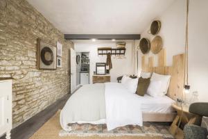 a bedroom with a white bed and a brick wall at The Grain store in Cirencester