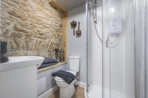 a bathroom with a shower and a toilet and a sink at The Grain store in Cirencester +23 photos