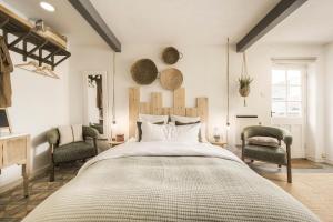 a bedroom with a large bed and two chairs at The Grain store in Cirencester