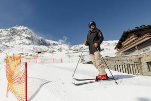 a man is standing on skis in the snow at Hotel Zürserhof in Zürs am Arlberg