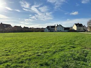 a large field of green grass with houses in the background at Modern Private Rooms in Chelmsford with Workspace & Free Parking in Chelmsford