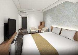 a hotel room with a bed and a television at Daiwa Roynet Hotel Ginza PREMIER in Tokyo +55 photos