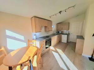 a kitchen with a wooden table and a table and chairs at Cosy Corner Cabin in Saint Merryn +2 photos