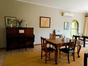 a dining room with a wooden table and chairs at Pecan Farm Guesthouse in Louis Trichardt