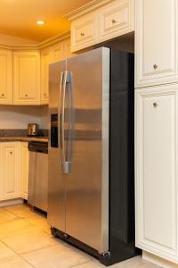 a stainless steel refrigerator in a kitchen with white cabinets at St Kitts Castle Suites in Basseterre