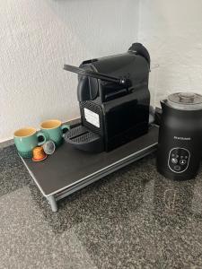 a coffee maker and two coffee cups on a tray at Maple and Vine in Hilton