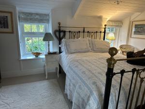 a bedroom with a bed and a window at Trewetha Cottage Bed & Breakfast in Port Isaac +8 photos