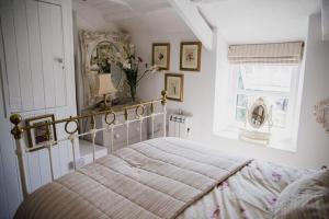 a bedroom with a bed and a mirror and a window at Trewetha Cottage Bed & Breakfast in Port Isaac