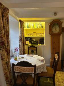 a dining room table with a cat sitting on top of it at Trewetha Cottage Bed & Breakfast in Port Isaac