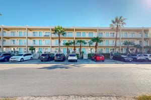 a large building with cars parked in a parking lot at Fiesta Sol Condominiums #109 in South Padre Island
