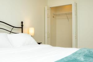 a bedroom with a white bed and a closet at St Kitts Castle Suites in Basseterre