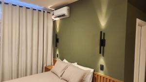 a bedroom with a bed and a air conditioner on the wall at Studio Cotia Próximo ao Thermas da Mata, Animalia Park e CT São Paulo in Cotia