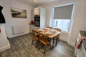 a kitchen and dining room with a table and chairs at Dog Friendly Lakeland Apartment - Private Parking - Central Location in Cockermouth