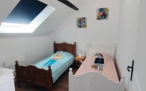 two twin beds in a bedroom with a skylight at Gîte Le Lyséas 6 personnes proche Forêt de Mormal & Animaux bienvenus in Bousies