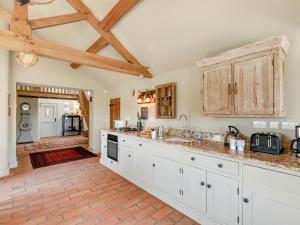 a large kitchen with white cabinets and a wooden ceiling at 2 Bed in York oc-g0073 in Ellerton