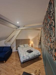 a bedroom with a bed and a blue couch at Cozy studio Libourne Train station within walking distance in Libourne