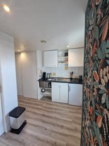 a kitchen with white cabinets and a counter top at Cozy studio Libourne Train station within walking distance in Libourne