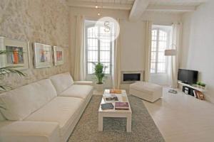 a living room with a white couch and a table at Côté Pur Arles Centre in Arles