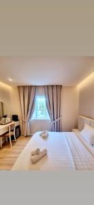 a bedroom with a large white bed with a window at Charles City Center in Tirana
