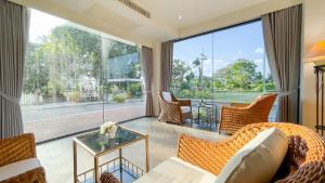 a living room with a couch and chairs and a large window at Rua Rasada Express in Trang