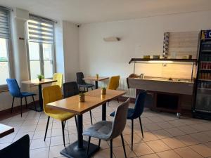 a restaurant with tables and chairs and a piano at Hôtel&Restaurant HDLV climatisées in Ornans
