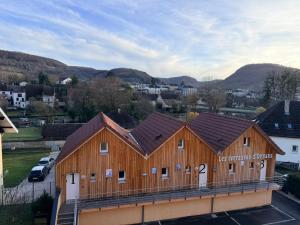 a large wooden building with brown roofs at Hôtel&Restaurant HDLV climatisées in Ornans
