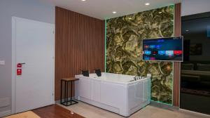 a bathroom with a sink and a tv on a wall at 313 Villa City Center in Tirana
