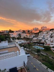 a view of a city at sunset from the roof of a house at Carmen Rooms -- Boutique B&B by the sea in Nerja