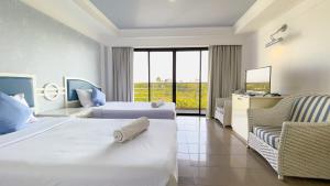 a hotel room with two beds and a chair at Rua Rasada Express in Trang