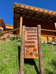 a sign in the grass in front of a building at Vila Florença Chales in Santa Teresa +1 photo