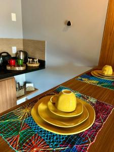 a yellow bowl and plates on a table at Vila Florença Chales in Santa Teresa